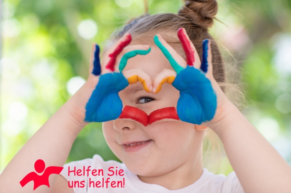 Mädchen mit bunt bemalten Händen, die ein Herz bilden.